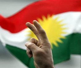 A protester make a victory sign with his hand in front of a Kurdish flag during a demonstration in Berlin